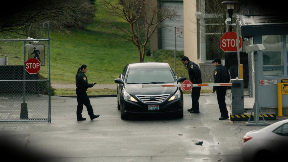 Guards check a car arriving at the facility through the first checkpoint.