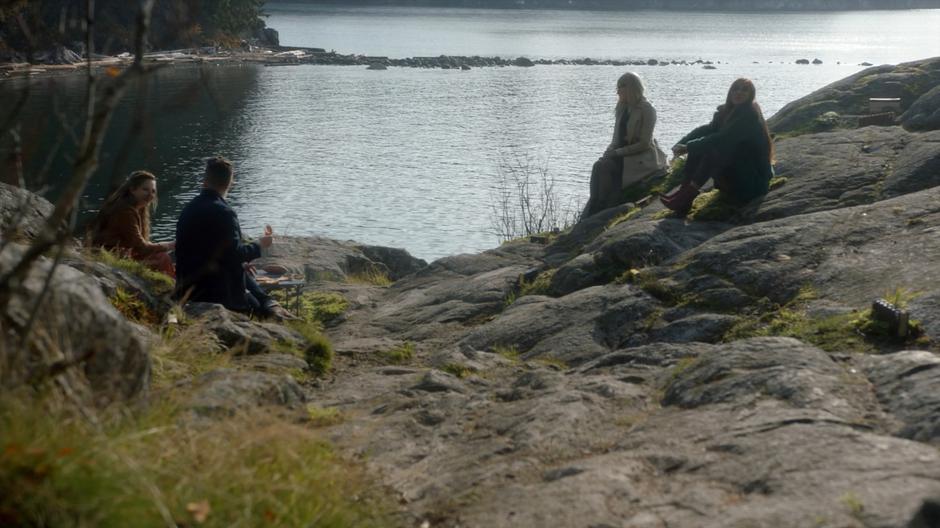 Fen, Josh, Alice, and Margo sit around the fire eating pizza and talking.