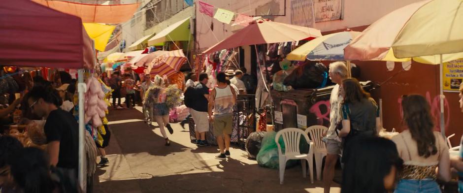 Harley runs down a busy market alley to escape Renee.