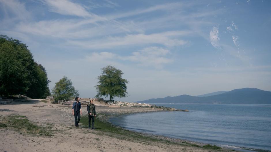 Eliot walks along the beach with Charlton looking for clues.