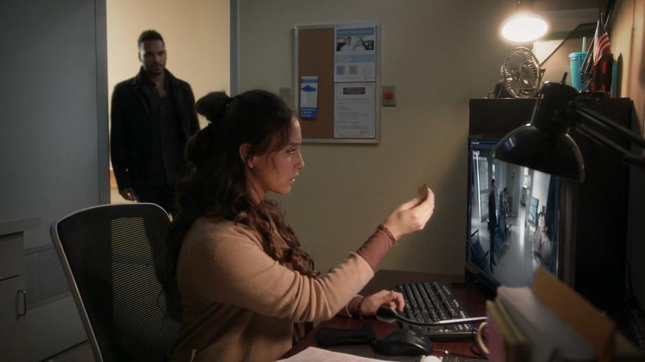 Penny enters the security room where Julia is watching security footage through a piece of glass.