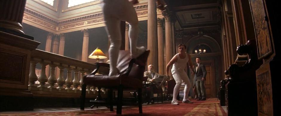 Bond leaps up onto a chair during his fencing duel with Graves.