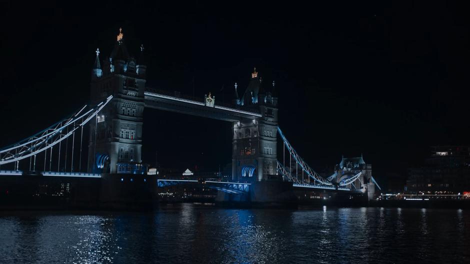 View of the bridge at night from over the river.