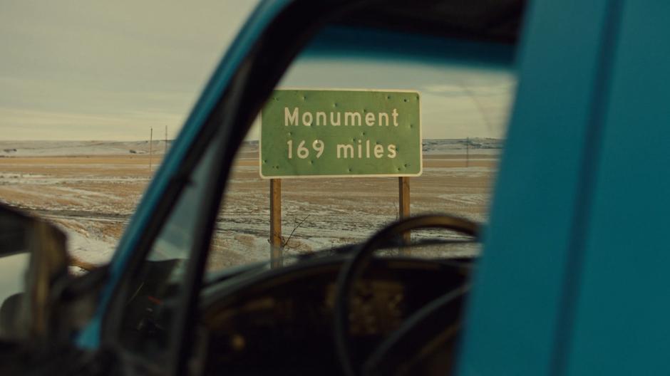 A bullet-marked sign announces another 169 miles to Monument.