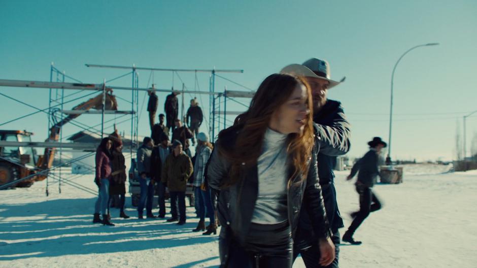 Sheriff Clayborn pulls Wynonna across the street towards the station while Doc runs off towards the homestead.