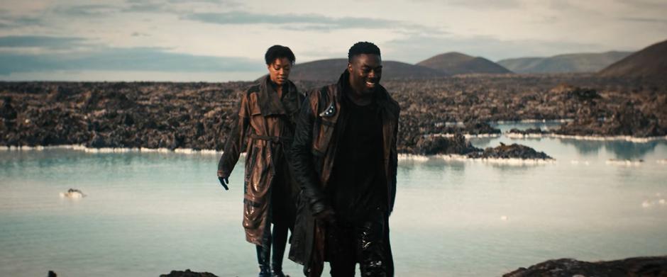 Booker smiles while walking out of the water with Michael behind him.