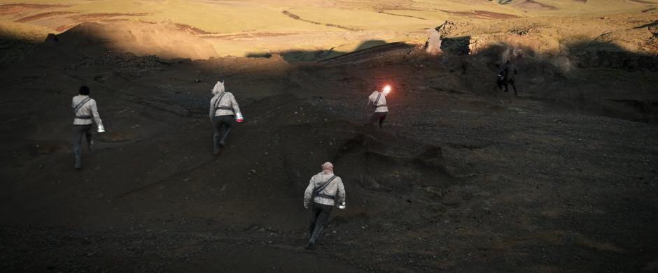 Four security guards run towards Michael and Booker as they duck behind a rock.