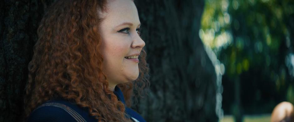 Tilly smiles while leaning against the trunk of the massive tree.