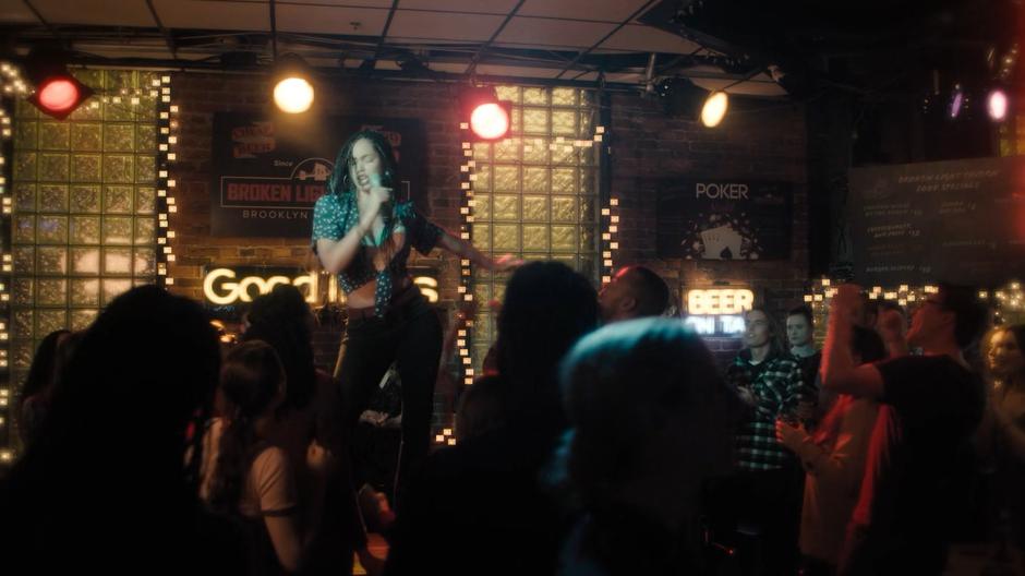 Young Macy dances while singing to the bar.