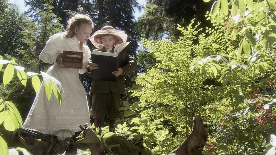 Katie and Sebastian examine some creatures in the forest.