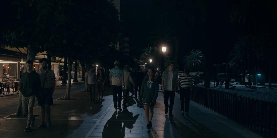 Ava looks around as she walks down the busy street next to the beach.