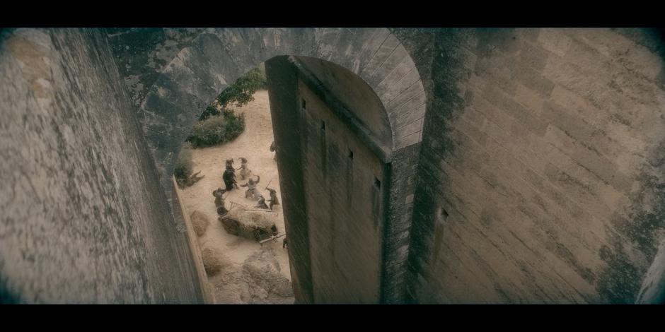 Groups of soldiers fight in the castle courtyard.