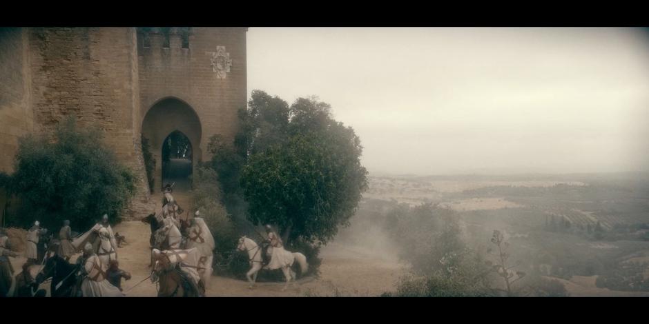 Riders race up the trail leading to the entrance of the castle.