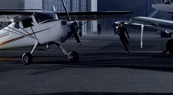 Max runs between some airplanes while being chased by guards.