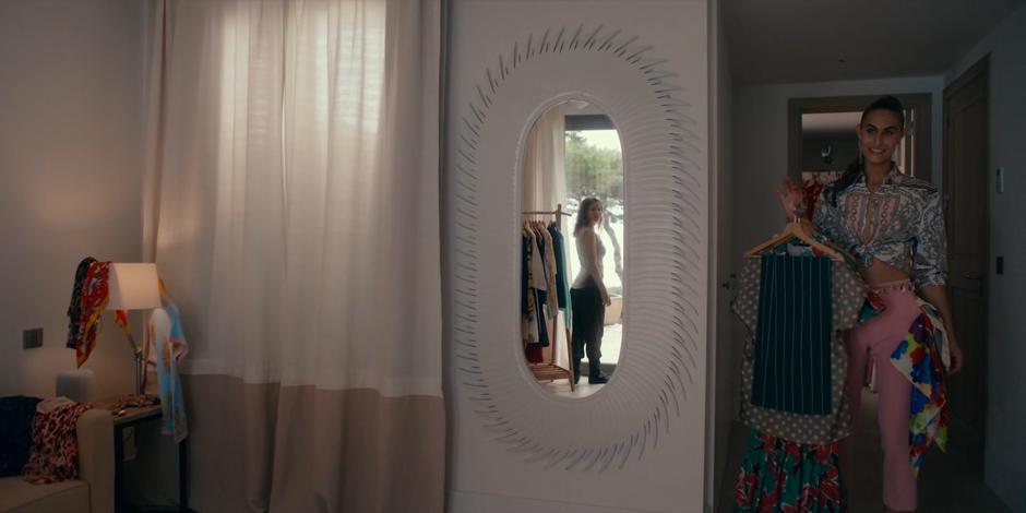 Ava is visible in the mirror turning around as Chanel comes out of the closet with some clothes for her to try.