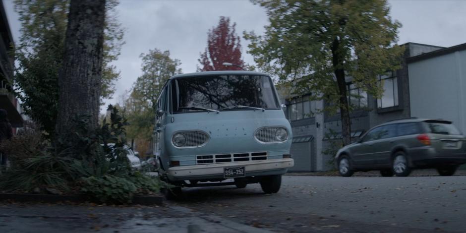 Ryan pulls her van to the curb in front of the comic shop.