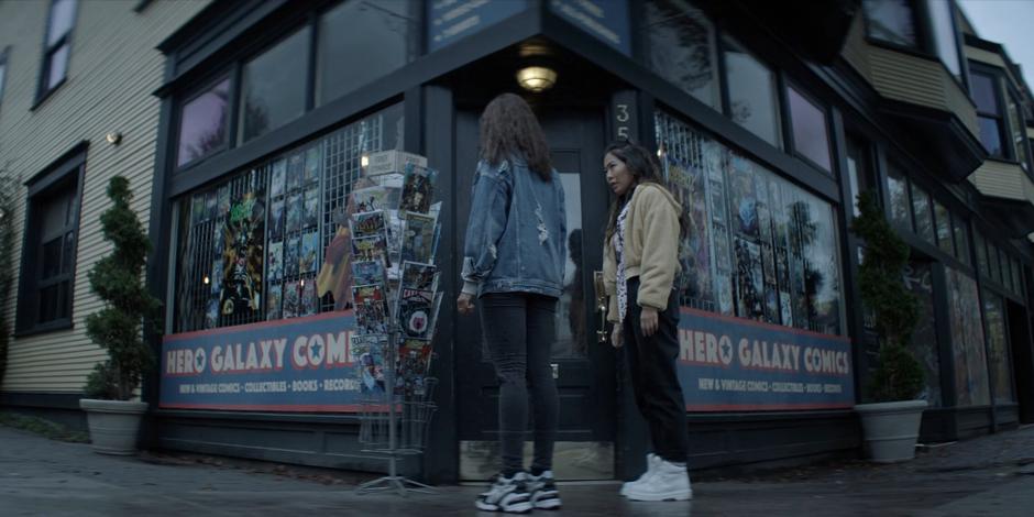 Mary talks to Ryan in front of the comic shop as Ryan is lost in memories.