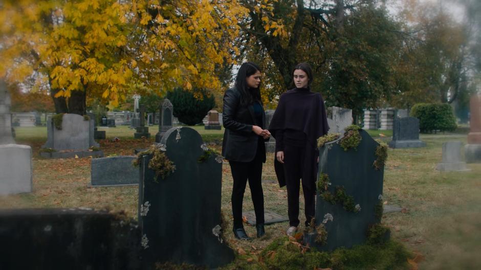 Mel and Abigael look down at Mel's grave.