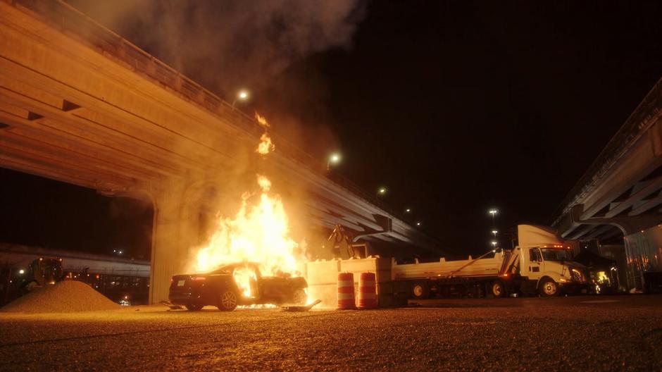 The car bursts into flames after hitting a stack of concrete blocks.