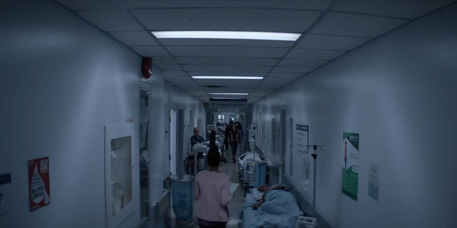 Angelique paces around the hallway where Ryan is waiting in the busy hospital.