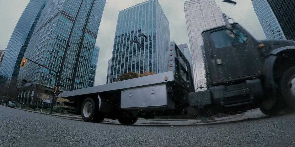 Glass flies everywhere as the truck crashes through the intersection.