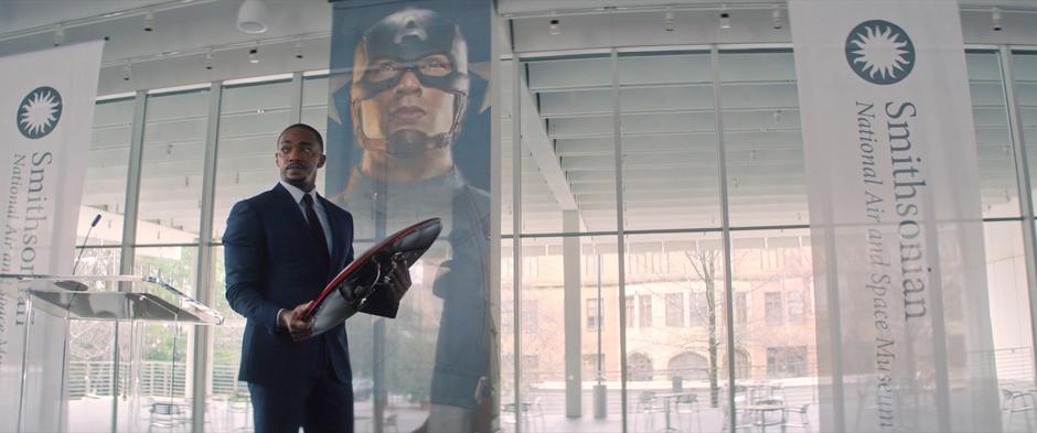 Sam looks out over the crowd as he carries the shield to the display case.