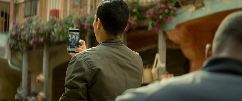 Joaquin uses his phone's camera to search around the street.