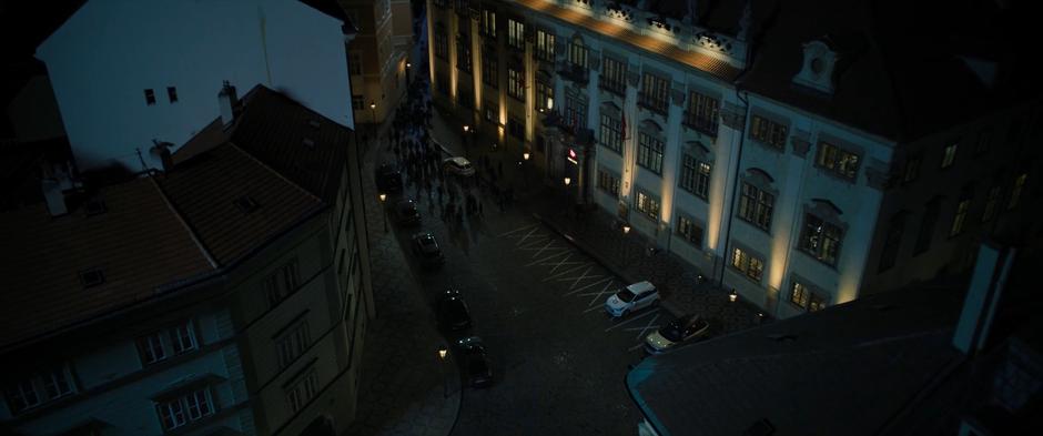 A group of people gather in the parking lot outside the bank.