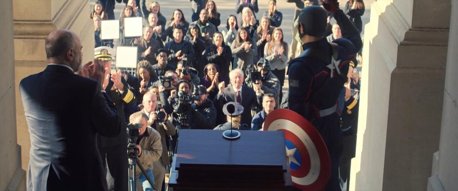 People clap as the new Captain America waves at the crowd.