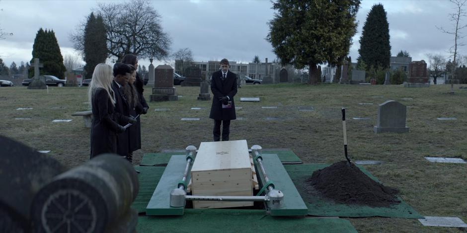 Julie, Luke, Mary, Sophie, and Jacob stand over Kate's coffin.