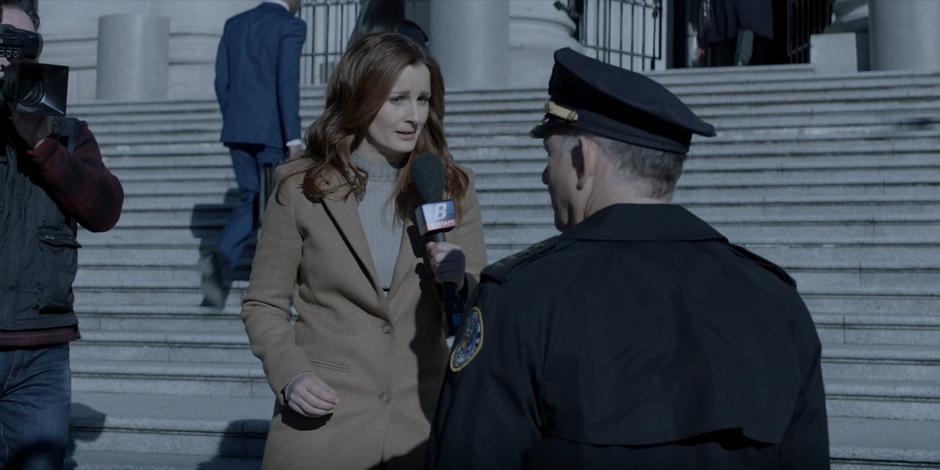 Dana Dewitt interviews Commisioner Forbes on the steps of the station about working with Batwoman.