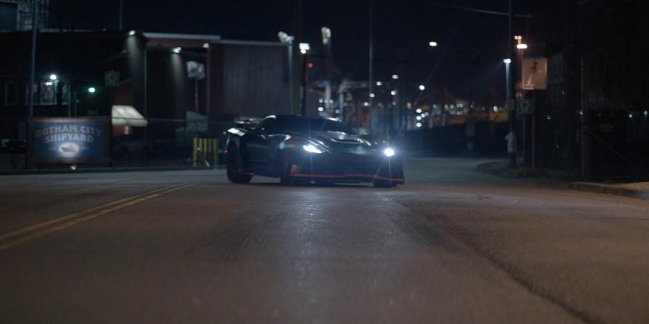 The Batmobile pulls up into the road blocking the green car.