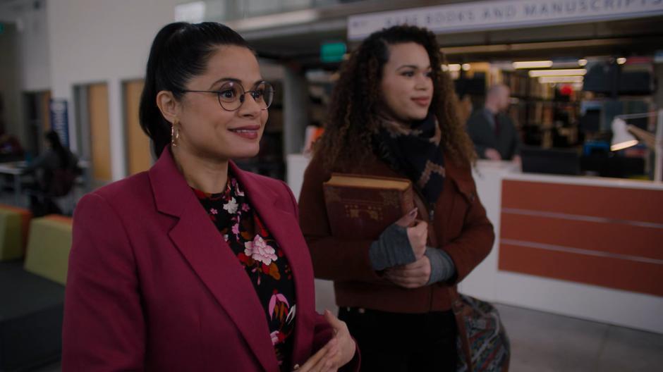 Josefina stands next to Mel as she smiles at the two professors who ignore her.