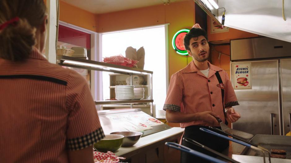 Behrad chats with Zari about his old burger job as he stands at the grill.