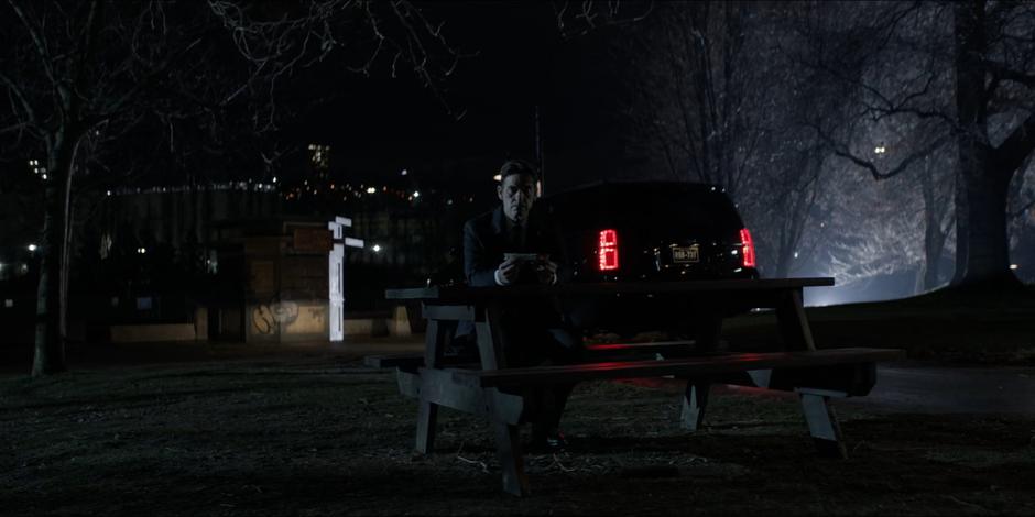 Jacob sits at the picnic table holding the Snakebite injector.