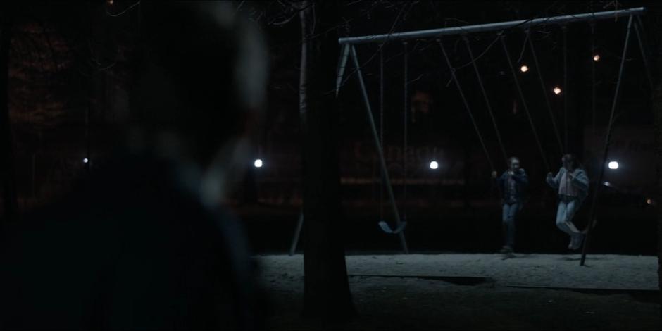 Jacob looks over and sees a vision of young Kate and Beth on the swings.