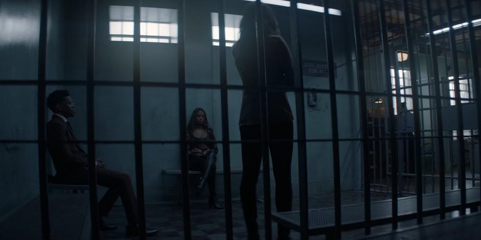 Luke and Ryan sit in the cell while Sophie stands and talks.