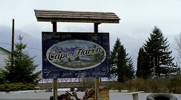 Max and Logan drive past the Cape Haven sign.