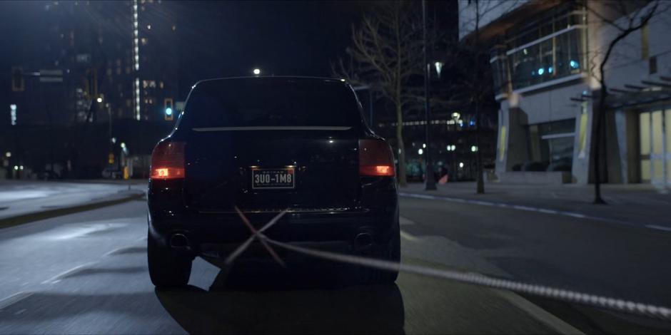 A grappling line shoots out from the Batmobile to the stolen car.