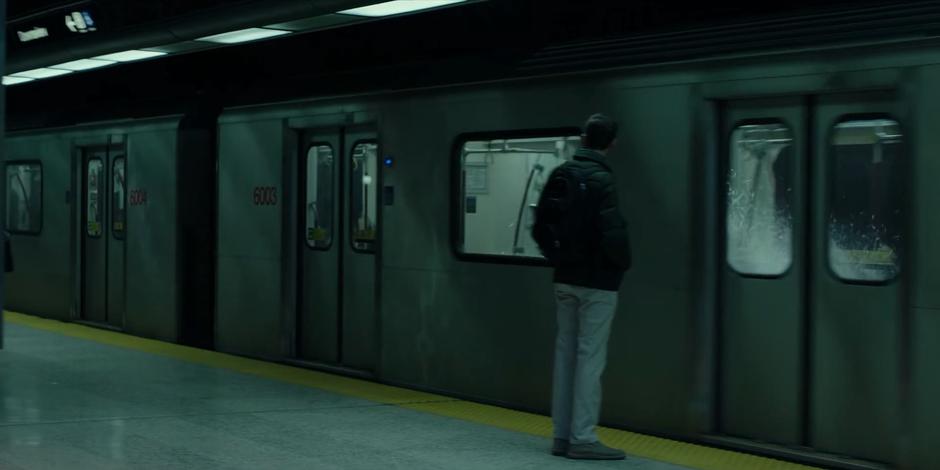 Water splashes against the window of the subway train as it pulls into the station.