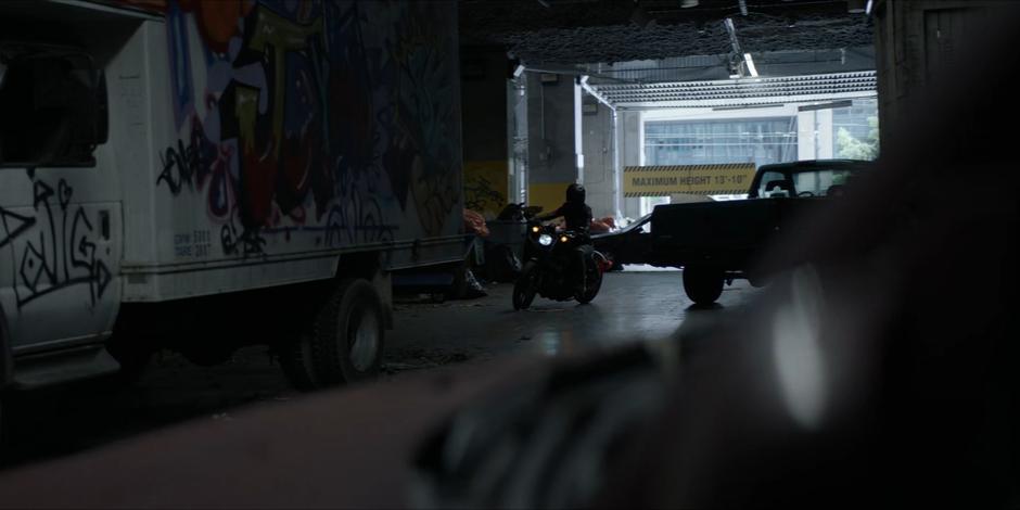 Kate parks her motorcycle in the abandoned loading dock.