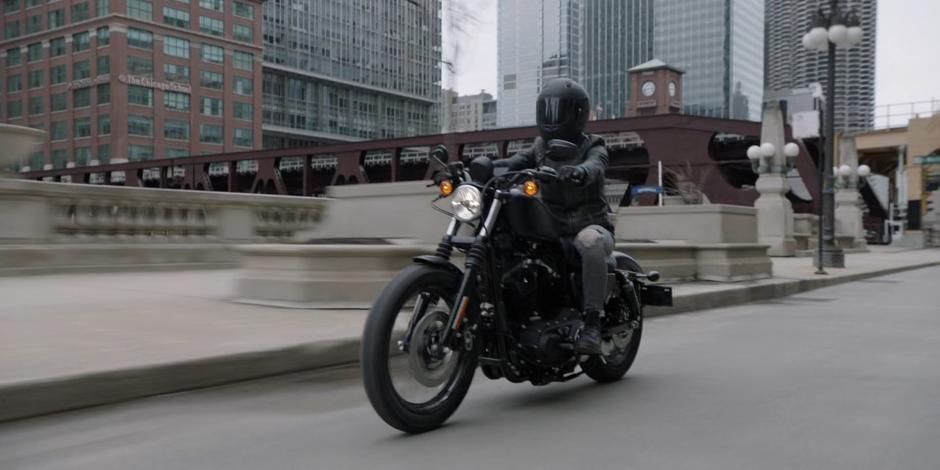 Kate speeds along the river on her motorcycle.