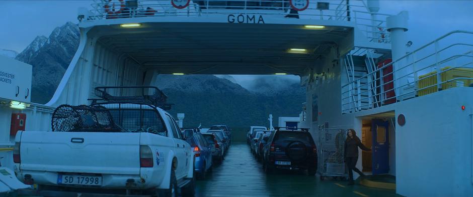 Natasha steps out on the deck of the ferry after her call with Secretary Ross.