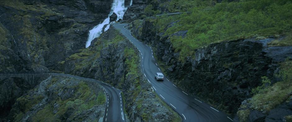 Natasha drives up a series of switchbacks past a waterfall.