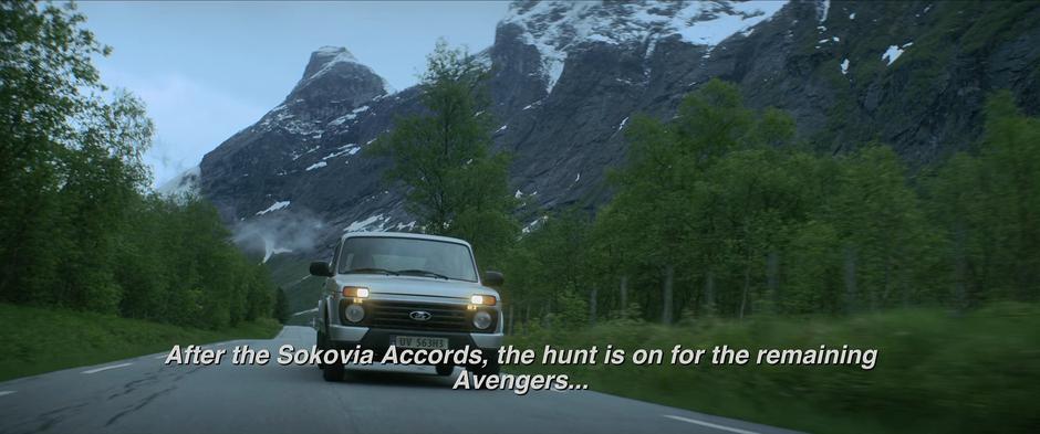Natasha drives down a road through the soaring mountains.