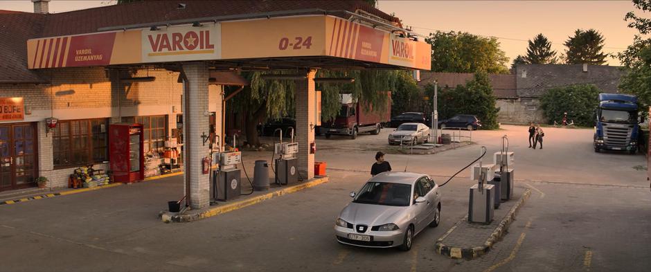 Natasha and Yelena walk to the gas station.