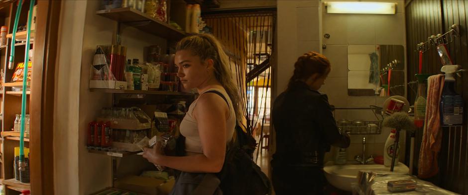 Yelena gathers medical supplies while Natasha washes her hands.