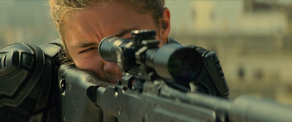 Yelena peers through the scope on her rifle.