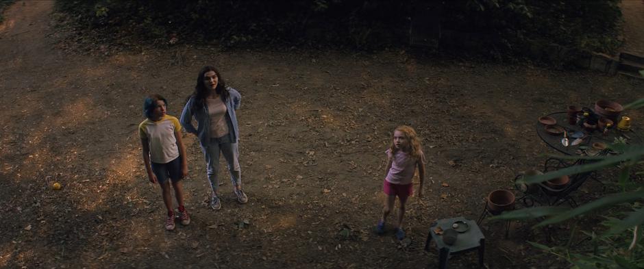 Natasha, Melina, and Yelena look up at the fireflies in the trees.