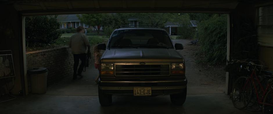 Alexei and Yelena load supplies into their car parked in the garage.